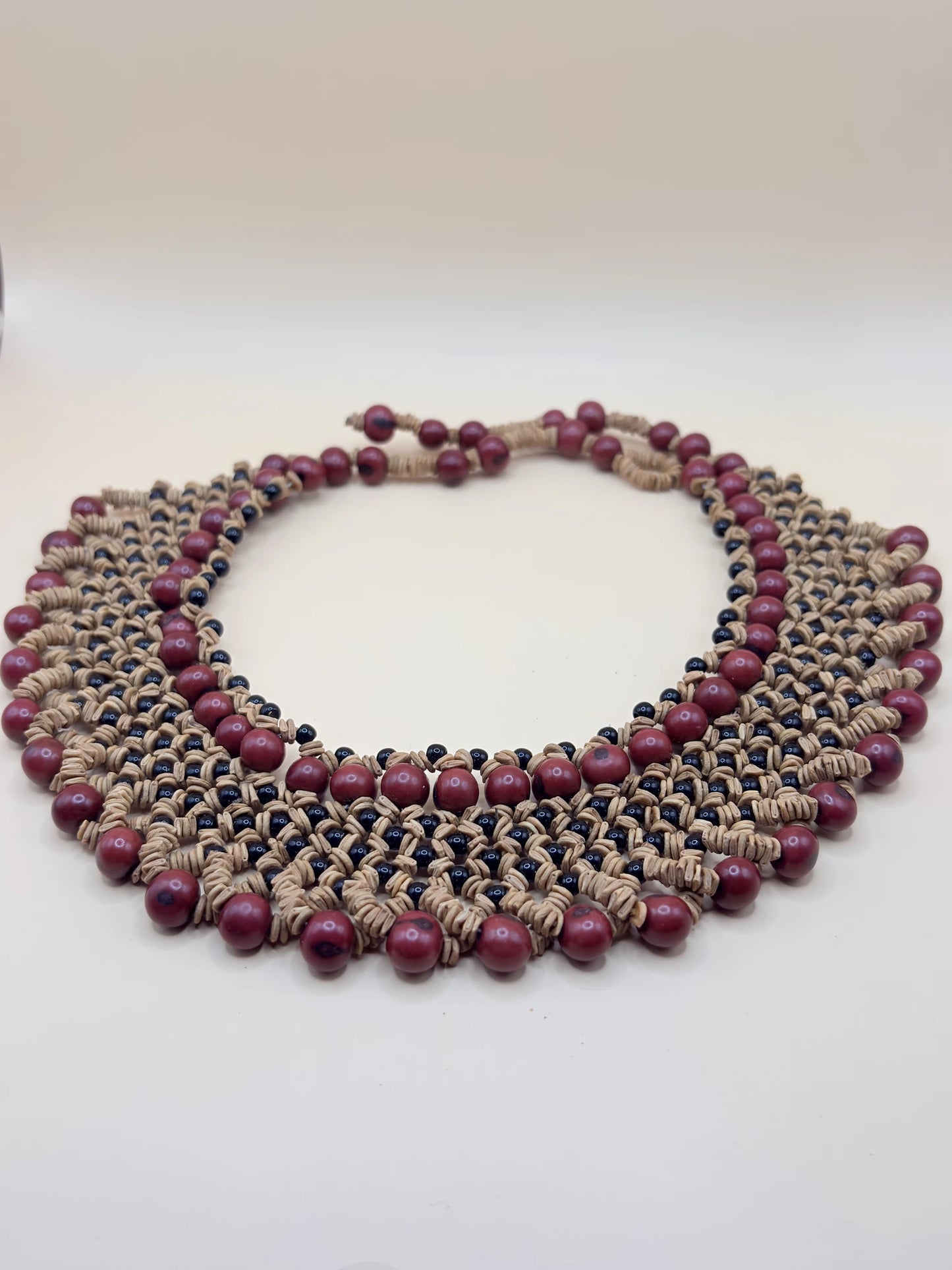 Grand collier bordeaux fabriqué par ddes femmes Satéré-Mawé en Amazonie, avec diverses graines locales