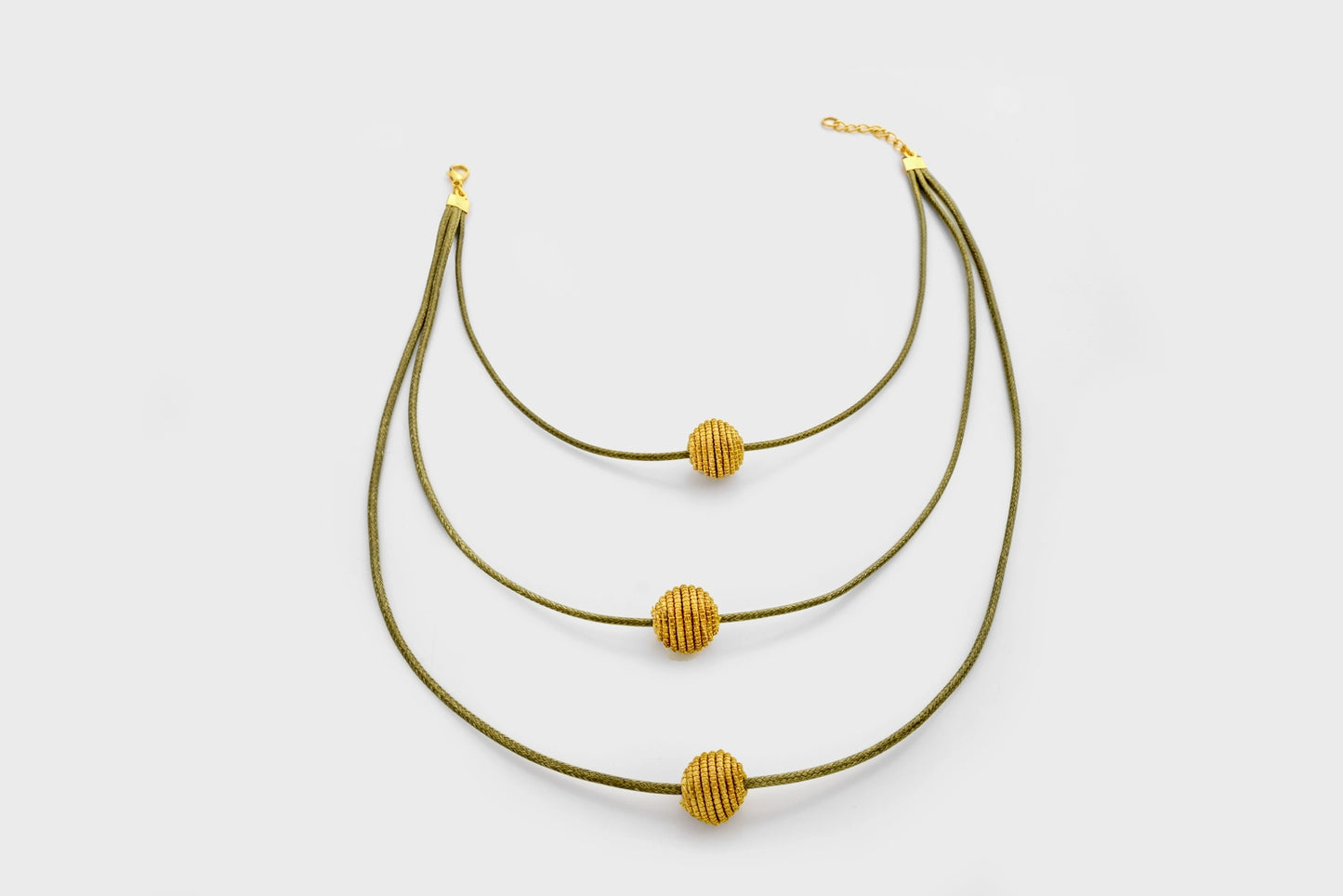 Collier en or végétal, retombant à différents niveaux sur le torse