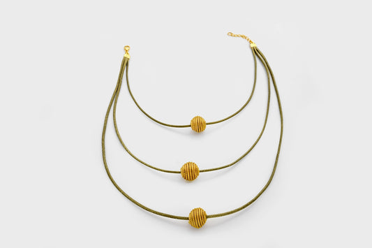 Collier en or végétal, retombant à différents niveaux sur le torse