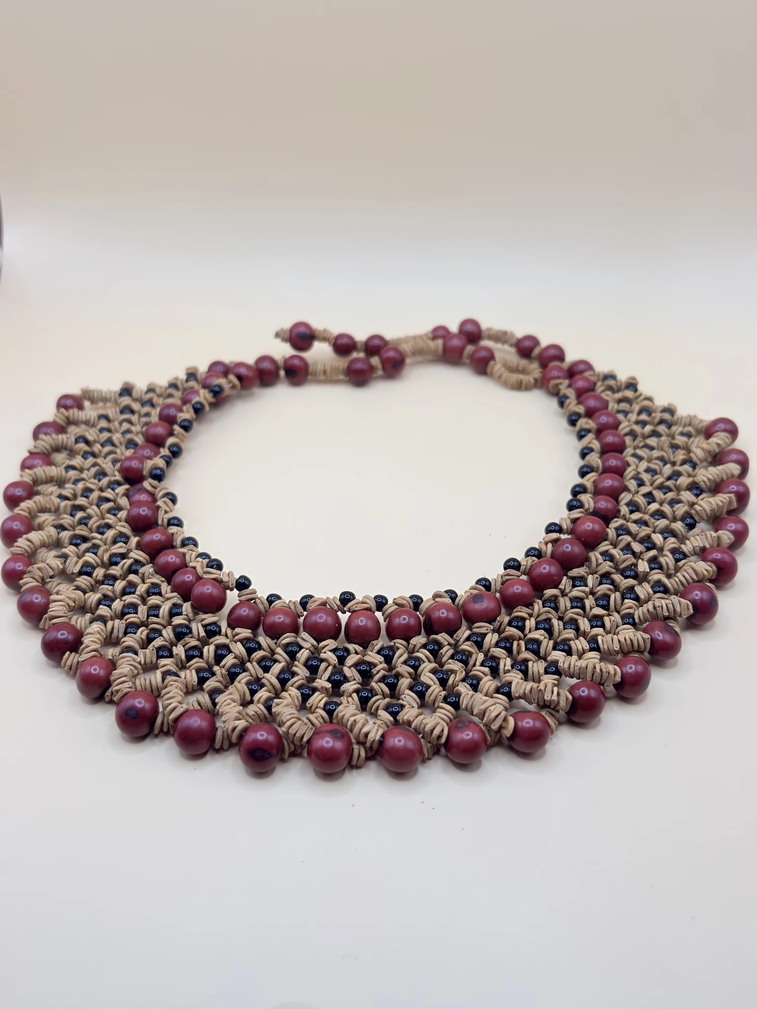 Grand collier bordeaux fabriqué par ddes femmes Satéré-Mawé en Amazonie, avec diverses graines locales