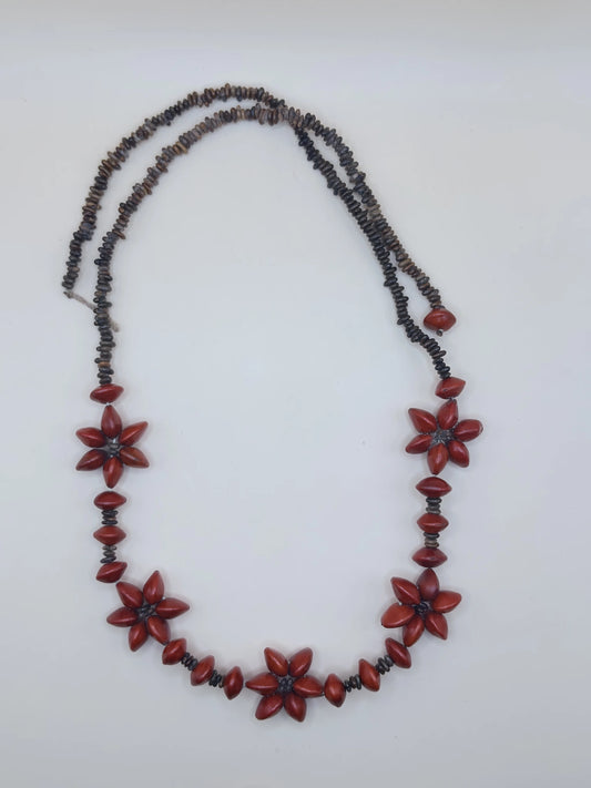 Collier en graines de tento représentant des fleurs, fabriqué en Amazonie